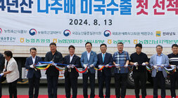 2024년산 나주배(원황) 대미 수출 첫 선적 행사 나주시장과 나주시의회 의장, 배원협조합장 및 관계자들이 선과장 앞 마당에 마련된 수출 첫 선적 대형 트럭 앞에서 테이프 컷팅 전 기념촬영을 하고 있는 모습