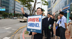 추석맞이 지역상품 판매 촉진 캠페인 및 청렴실천, 고향사랑 기부제 홍보 캠페인 나주시장이 나주사랑카드 이용 피켓을 들고 지나가는 차량을 향해 손을 흔들며 홍보켐페인을 벌이고 있는 모습