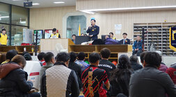  윤병태 나주시장이 무대 위에 올라 연설하고 있고, 많은 관람객들이 바닥에 앉아 연설자를 바라보고 있는 볼링장 내부 전경