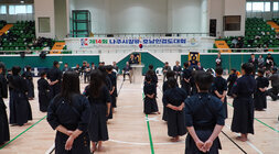  실내 체육관에서 검도 대회 개회식이 진행되는 모습. 검도복을 입은 많은 선수들이 도장 위에 도열해 있고, 단상 위에서는 윤병태 나주시장이 연설하고 있다. 배경에는 '제14회 나주시장배 호남인검도대회'라는 현수막이 걸려있다.