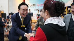  윤병태 나주시장이 한 중년 여성 참석자와 악수를 나누며 활짝 웃고 있는 모습