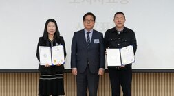 두 명의 수상자(여성 1명, 남성 1명)가 한 남성(중앙)과 함께 상장을 들고 기념 촬영하는 모습. 배경 스크린에 '도지사 표창'이 보임