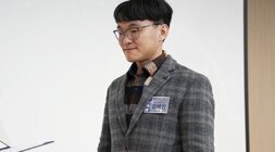  시상을 위해 '강해민' 명찰을 단 남성이 서류를 바라보며 미소 짓는 모습