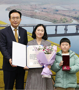 6.25전쟁 무공훈장 전수 나주시장과 유공자 가족인 손녀, 손녀의 아들과 함께 기념촬영을 하고 있는 모습