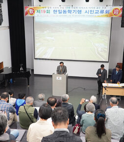 제19회 한일동학기행 시민교류회 나주시장의 축사모습과 참석자들이 자리에 앉아 있는 모습