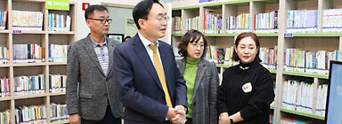 LH5단지 프로그램 성과나눔 전시회 나주시장이 LH5단지 도서관의 프로그램에 대해  관계자의 설명을 듣고 있는 모습