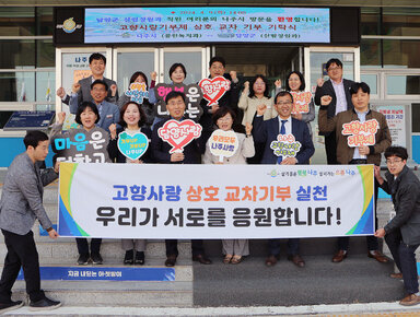 고향사랑 기부 상호 교차 기탁식 나주시 부시장과 공원녹지과장 및 직원, 담양군 산림정원과장 및 직원을이 나주시 플래카드를 펼치고 기념촬영을 하고 있는 모습