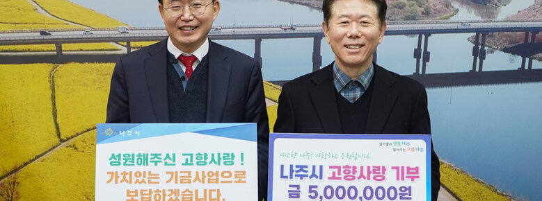 고향사랑 기부금 기탁식 나줏지아과 디투 엔지니어링 대표가 판넬을 들고 기념촬영을 하고 있는 모습