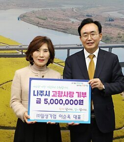  살기좋은 행복 나주 앞서가는 으뜸 나주 내고향 나주! 사랑하고 응원합니다. 나주시 고향사랑 기부 금 5,000,000원 함께 합니다. 같이 합니다. (주)일성기업 이순옥 대표 라고 적힌 팻말을 들고 사진을 찍고 있는 이순옥 대표와 윤병태 시장