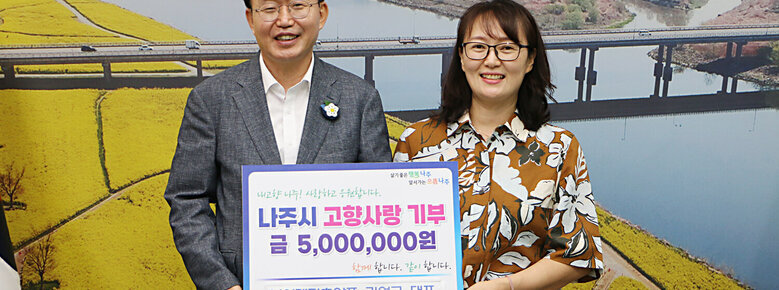 살기좋은 행복 나주 앞서가는 으뜸 나주 내고향 나주! 사랑하고 응원합니다. 나주시 고향사랑 기부 금 5,000,000원 함께 합니다. 같이 합니다. (주)이레가축약품 김영국 대표 팻말을 들고있는 윤병태 시장과 안경을 낀 여성
