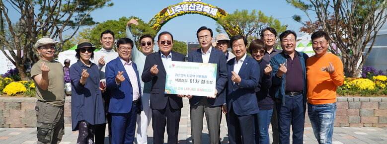 2024나주영산강 축제 | 나주시고향사랑기부제 2년 연속 최고액 기부동참 석창건설 이재철 회장 내 고향 나주시를 응원합니다! 라고 적힌 팻말을 들고 있는 이재철 회장과 윤병태 시장 뒤로 11명의 직원일동이 손하트를 하고 있다