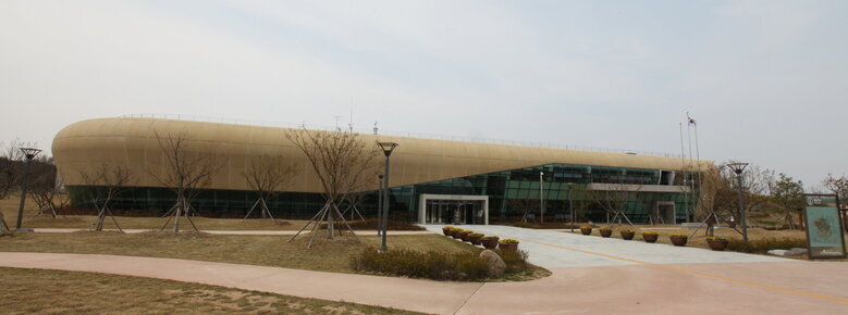 나주국립박물관 전경을 찍은 사진. 잔디밭뒤로 양끝이 둥근형태의 박물관 건물이 보임. 