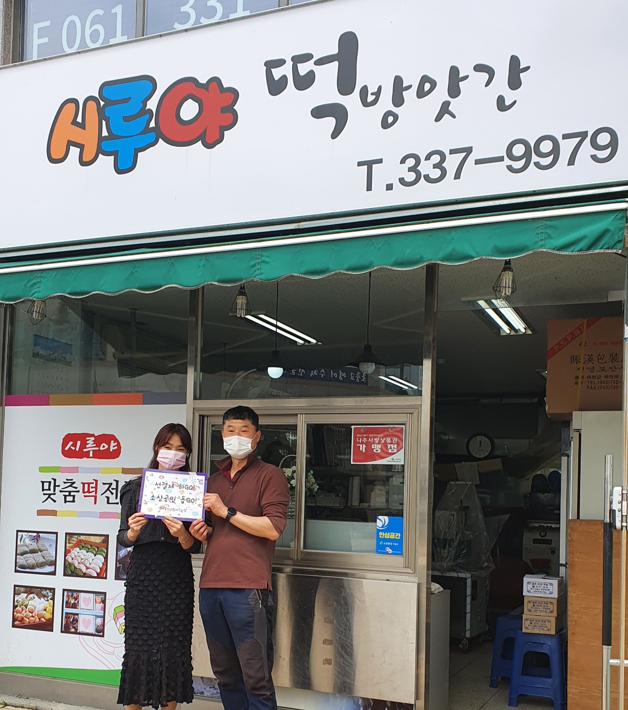 선결제 캠페인 안내판을들고 가게정문앞에서 촬영한 사진