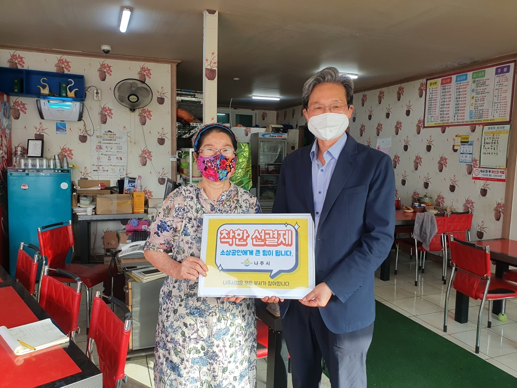 선결제 캠페인 안내판을들고 가게안에서 촬영한 사진