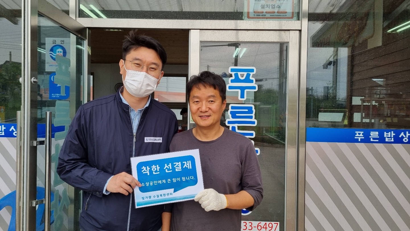 선결제 캠페인 안내판을들고 가게정문앞에서 촬영한 사진